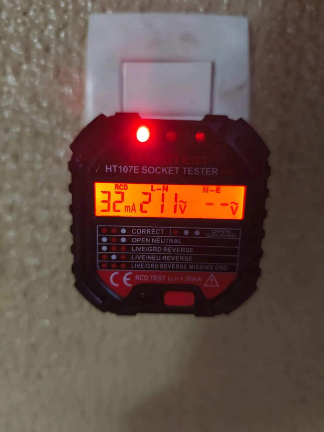 Testador de tomadas digital mostrando tensão de 211 V e teste de DR