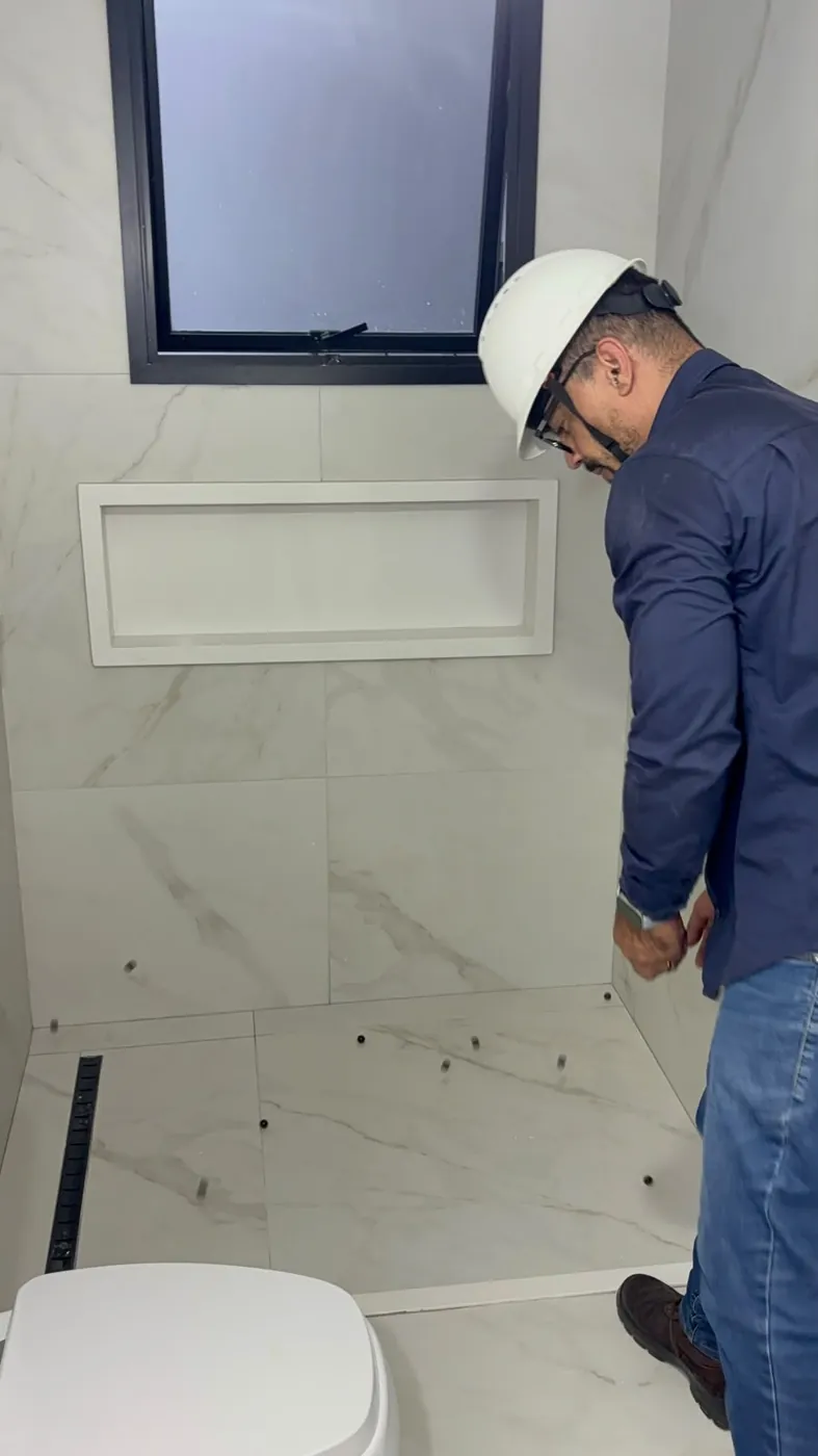 Esferas espalhadas no piso do box para testar o caimento até o ralo
