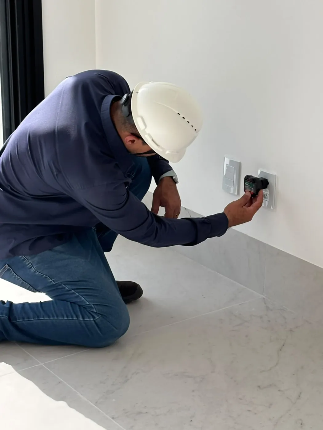 Engenheiro conectando o testador em uma tomada do quarto